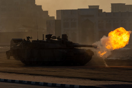 Army tanks shooting and driving in the desert town in war and military conflict. Military concept of war and explosions.のeditorial素材