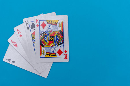 Full house hand of cards on bright blue flat lay in a game of texas holdem poker gambling at a...