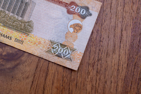The Currency of the United Arab Emirates (UAE) - Close up of a two hundred Dirham note  on a brown table background. Money exchange.の写真素材