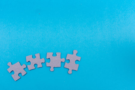 Puzzle pieces blank about to connect on bright blue flat lay background for team work, unity,...