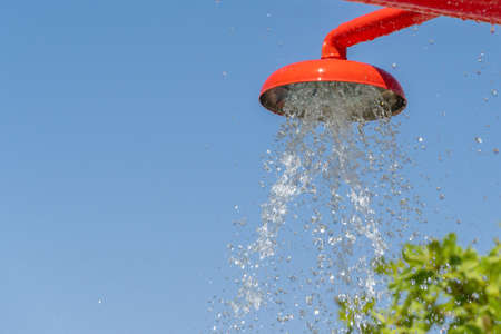 Water falling from bright colored red fountain to pool below. Copy space left.の写真素材