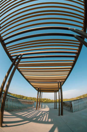 A portrait artistic fisheye view of a pavillion looking over the water, rest area and blue sky.の写真素材