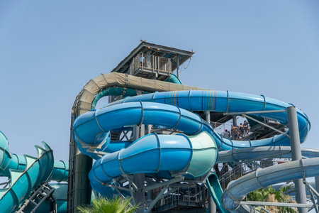 Blue water Park twisted water slide amusement resort for luxury children and family vacations on a warm sunny tropical day with blue sky.のeditorial素材
