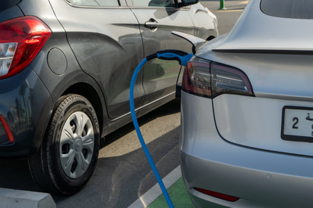 2.26.2022 - Dubai, UAE - Tesla Electric vehicle only charging station sign for environmentally friendly vehicles in parking lot in middle east.のeditorial素材