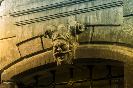 Head of the stone gatekeeper is located above the entrance of an ancient houseの写真素材
