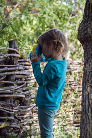 Little girl with a toy camera in the creative processの写真素材