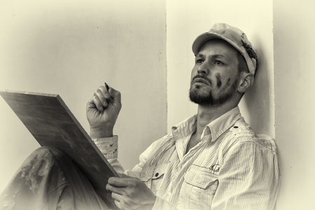 Master tiler with a smart look performs calculations. Man true tilerの写真素材