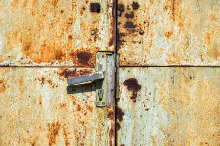 Doorknob on an old rusty metal doorの写真素材