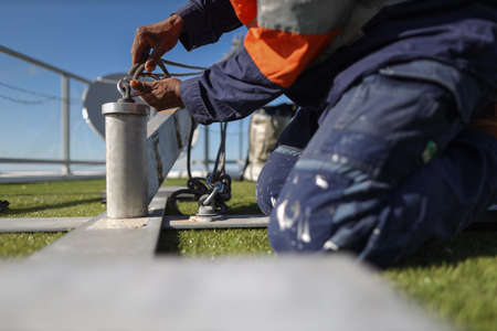 Rope access engineer inspecting clipping Carabiner which attached on rope into portable lightweight...