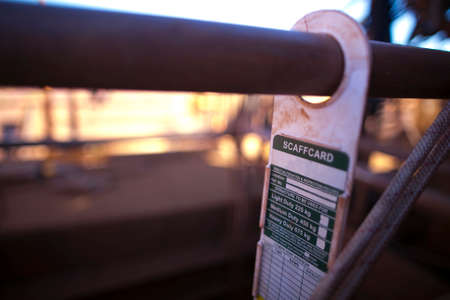 Scaffolding tag label safety warning sign displaying hanging on the scaffold tube at construction...