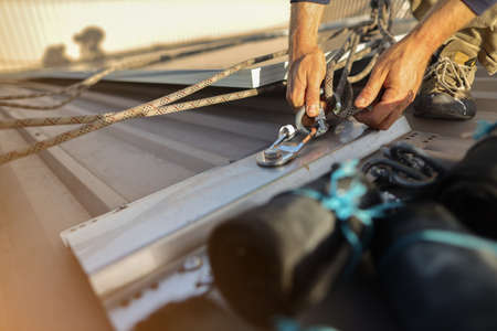 Close-up of a man's hands tying a rope on a sailing boat.