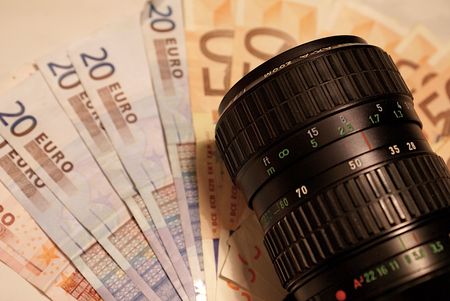 Reflex camera lenses over 20 and 50 Euro notes, showing working for microstock sites pays when you do your best to create quality shots.の写真素材