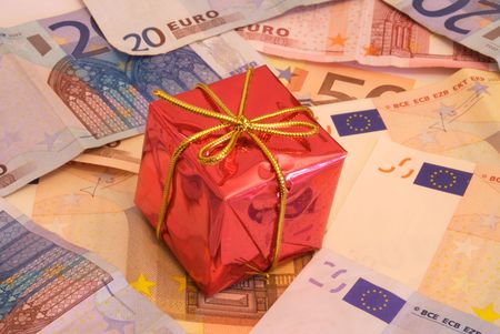 Christmas presents over a bunch of money (Euro bills) that represents how much important money is in today's consumist society, specially when Christmas comes.の写真素材