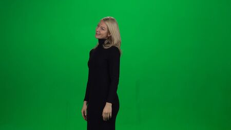 Young female is standing with tender smile. Green screenの写真素材