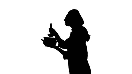 Portrait of black silhouette of a cook lady in uniform trying dish.の写真素材