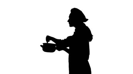 Portrait of black silhouette of a cook woman in uniform trying dish.の写真素材