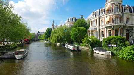 Traditional canal in old center of Amsterdam, Holland. Beauty of old european city centre. Cityscape in spring at sunny day.の写真素材