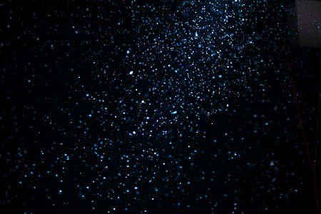 Wonderful winter snowfall. Snow motion filmed with studio lighting on a black background. Close up.の写真素材