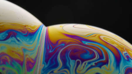 Soap bubble macro rainbow colors creating multicolored patterns. Colorful foam soap bubble slow motion. Very similar to other galaxy planets. Close up.の写真素材