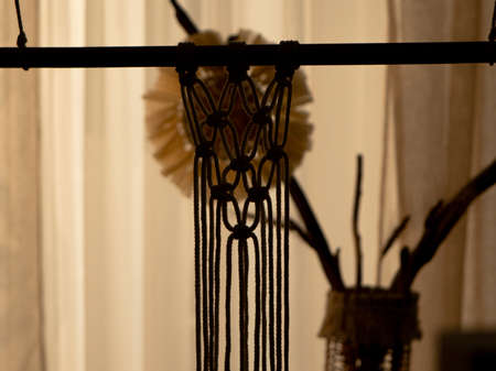 Pattern of whites macrame threads on a stick for decoration or home decor. Home decor idea handmade...