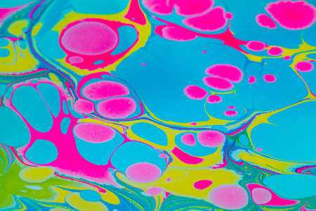 Colorful background with pink, blue and yellow marble spots in Turkish ebru technique. Unique...