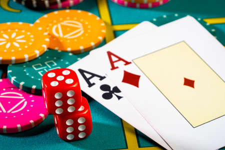 Casino chips with dice and playing cards on game table. Concept of gambling or poker and...