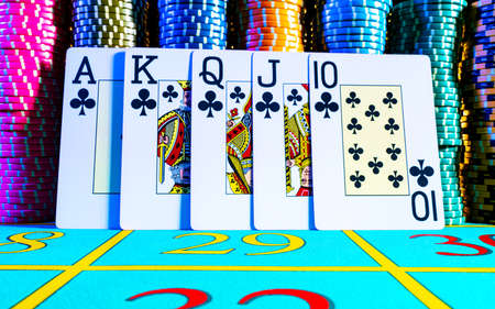 Royal flush, straight flush from ten to ace on the background of game chips for playing poker....