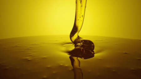 Honey dripping, pouring from spoon. Thick viscous honey molasses dripping. Close up of golden honey...