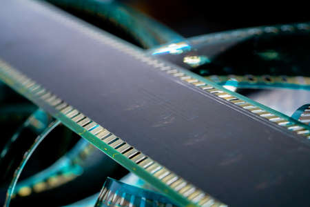 Black strips of old analog film with scratches and scuffs. Photo or video film for films or pictures close up. The concept of retro cinematography, photography, photographic memories.の写真素材