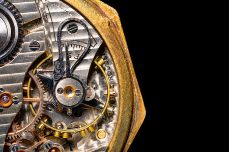 Rear viev of a old pocket watch with an open clockwork on black isolated background. Retro clock,...