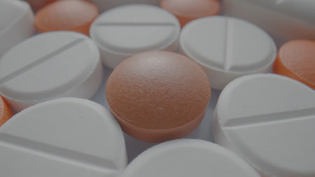 Pattern from medical tablets and pills. White and brown round assorted medicines close up. Pharmaceutical or medical background. Vitamins, antibiotics, painkillers.の写真素材