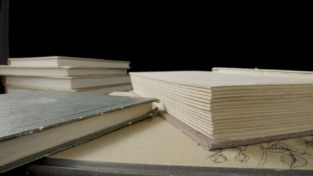 Open book with white paper pages isolated on black studio background. Old books with shabby covers...