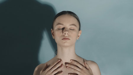 Attractive woman model with closed eyes and nude makeup touching her body smooth skinの写真素材