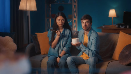 Fun, food and young couple eating ice cream in a kitchen at home, bonding, playful and looking...