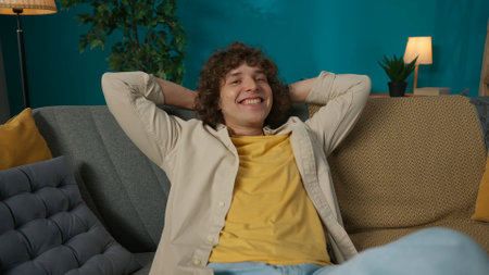 Young man in casual clothing, sitting on the couch in the room taking a nap, closeup shot.の写真素材