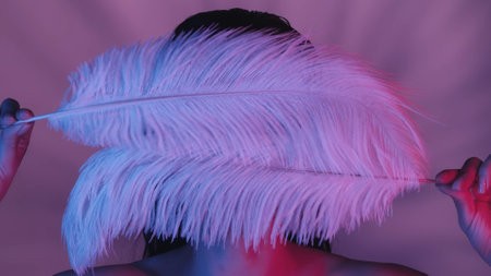 Close up shot of a seminude young womans face and body. Shes covering her face with two white...