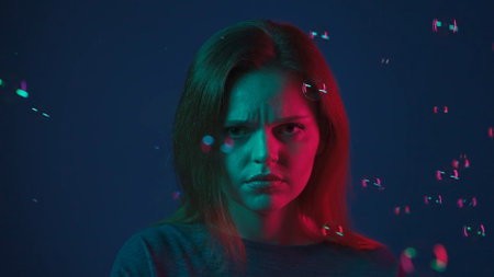 Portrait of a dissatisfied redhaired woman surrounded by soap bubbles in the studio on a blue...