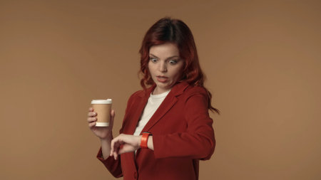 Medium isolated shot of an astonished, surprised young woman looking at her watch in shock, as if...