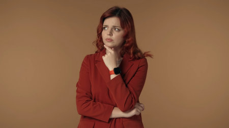 Medium isolated shot of a young woman pensively looking away as if shes trying to come up with an idea or doubting some decision, while touching her chin.の写真素材