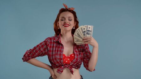 Framed against a blue background is a young red-haired woman with brightly colored makeup. Holding a...