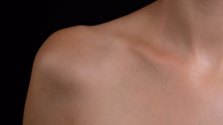 Portrait of an attractive caucasian female model. Closeup studio shot of young female model body part, clavicle shoulder area smooth skin.の写真素材
