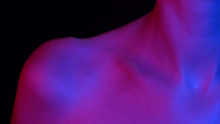 Portrait of appealing caucasian female model. Closeup studio shot of young woman body part in neon...
