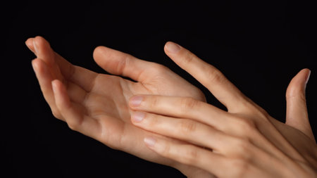 Closeup studio shot of beautiful caucasian woman showing open palm and touching it with finger,...