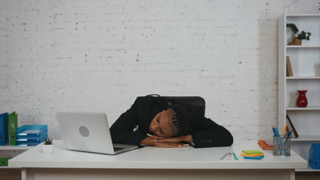 Modern businesswoman creative concept. Woman taking break, napping on the desk, laying her head on hands, sleeping during work.の写真素材