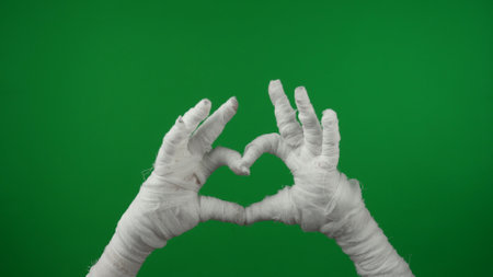Detail green screen isolated chroma key photo capturing mummys hands raised up in the air, making a heart with its fingers.の写真素材