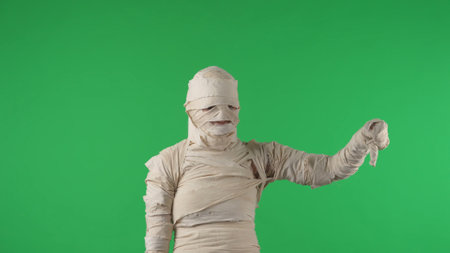 Green screen isolated chroma key photo capturing a mummy staring at the cameta and giving a thumbs down, dissatisfied with something.の写真素材