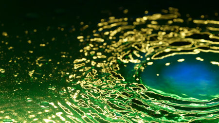Green ink paint colored water with blue surface oil drops floating waves, abstract wallpaper...