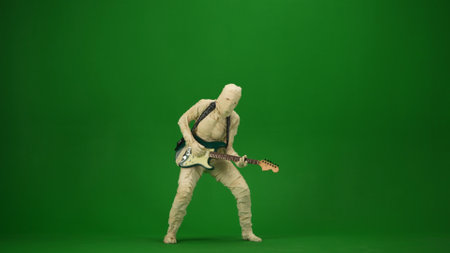 Green screen isolated chroma key photo capturing a mummy playing guitar and dancing to the music. Mock up for your promotion clip or advertisement. Full length.の写真素材