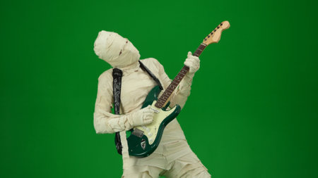 Green screen isolated chroma key photo capturing a mummy playing guitar and dancing to the music. Mock up for your promotion clip or advertisement. Medium sizeの写真素材
