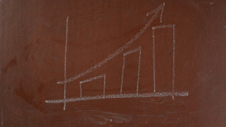 Textured brown chalkboard background. Growth graph, chart sketched on the board with a piece of white chalk in close up.の写真素材
